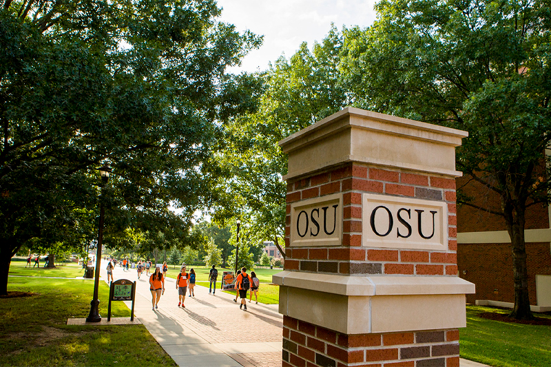 OSU Pillar and students walking, fall campus scene