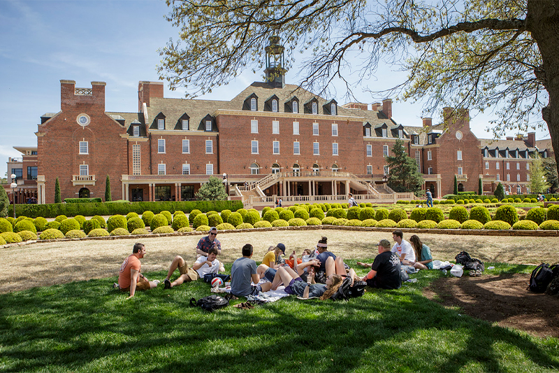 students on library lawn gather for pre-summer picnic
